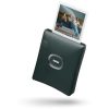 Green Instax instant camera printing a polaroid-style photo that emerges from the top.