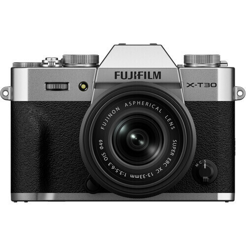 Front view of a silver and black Fujifilm X-T30 mirrorless camera with a lens attached.
