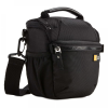 Black compact camera bag with top handle, adjustable shoulder strap, and zipped compartments including a front pocket for accessories (Case Logic logo).