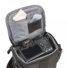 Open camera bag with a digital camera inside the main compartment and small pockets holding a memory card case and a tissue/cloth accessory