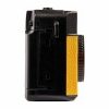 Side view of a black compact camera with a yellow textured grip and a large control dial on the right side