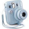 Pastel blue Instax Mini 13 instant camera with lens extended and wrist strap.