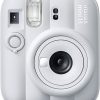 Front view of a white Instax Mini 13 instant camera with lens, flash, and viewfinder visible.