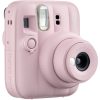 Pink Instax Mini 13 instant camera with lens extended, facing slightly to the right.