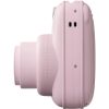 Side view of a pastel pink instant camera with a protruding lens and rounded body.