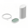 White Sonos portable smart speaker with fabric grille and a circular charging dock with green pad nearby, connected by a cable