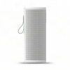 White portable speaker standing upright with a perforated front grille and a green wrist strap on the left.