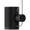 Black cylindrical smart speaker with a round mounting dock attached to its side and a power cable plugged in.