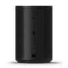 Tall black wireless speaker seen from the back, with perforated side grills and a central vertical panel showing USB port, LED indicator, and power/socket area.