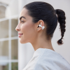 Profile of a woman wearing white wireless earbuds in her right ear, hair in a ponytail.