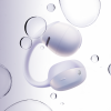 White wireless earbuds with a curved neckband-like band floating among clear bubbles in water-based backdrop.