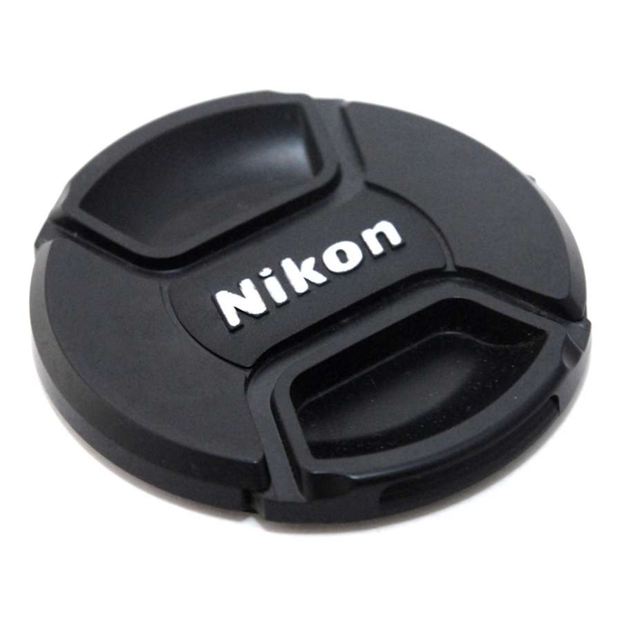 136721_0-900x900-1jpg | Kounio.gr Black Nikon camera lens cap with white Nikon logo on a white background, resting flat.