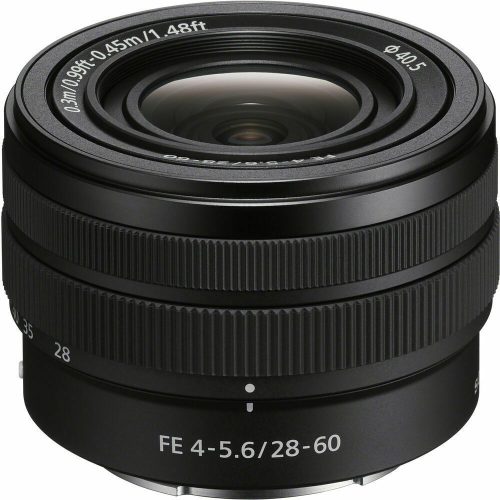 Close-up of a Sony FE 4-5.6/28-60 lens with textured rings and the front element visible, showing white markings and measurements