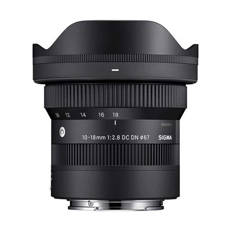 Sigma 10-18mm f/2.8 DC DN lens with hood mounted on the front element, black compact zoom lens for mirrorless cameras
