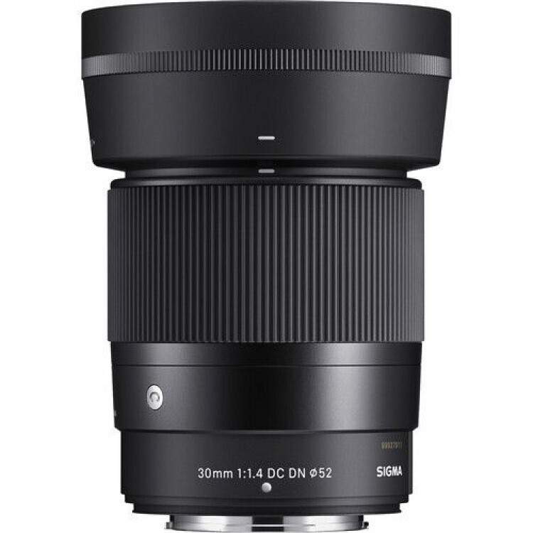 Sigma 30mm f/1.4 DC DN lens for mirrorless cameras, black with textured grip visible in the midsection and front element cap edge.