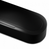 Close-up of a black wireless speaker with a perforated grille and a silver volume slider marked + and -