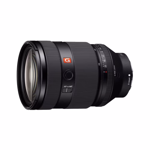 Black camera lens with a textured zoom ring and orange G logo on the side, shown in side view.