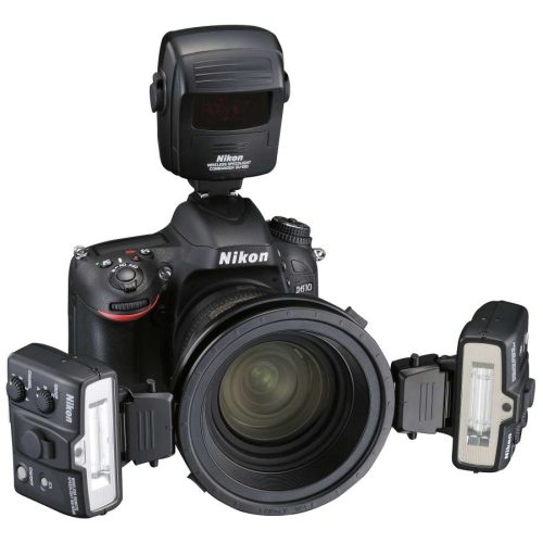 Nikon DSLR with a large lens and multiple external flashes mounted on the sides and top for studio lighting.
