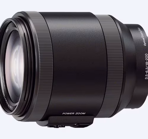 Close-up of a black camera lens with visible focus/zoom rings and 'Power Zoom' label on a light background.